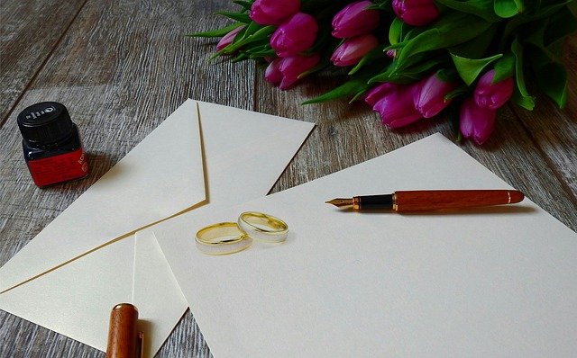 obálka s dopisem, prstýnky, květinou – jak jen napsat, že se chystá svatba